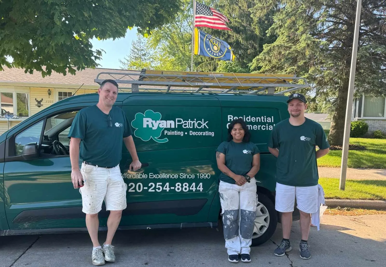 The team of professional residential and commercial contractors at RyanPatrick Painting & Decorating posing outside in front of their van.